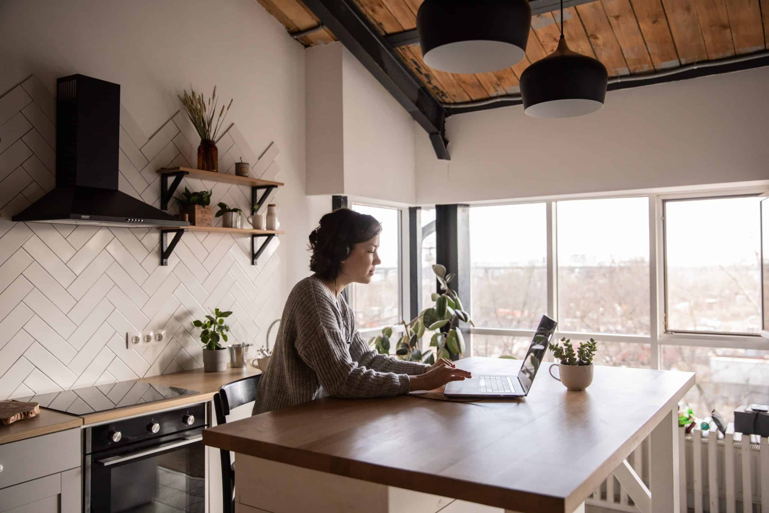 Woman at kitchen counter on laptop